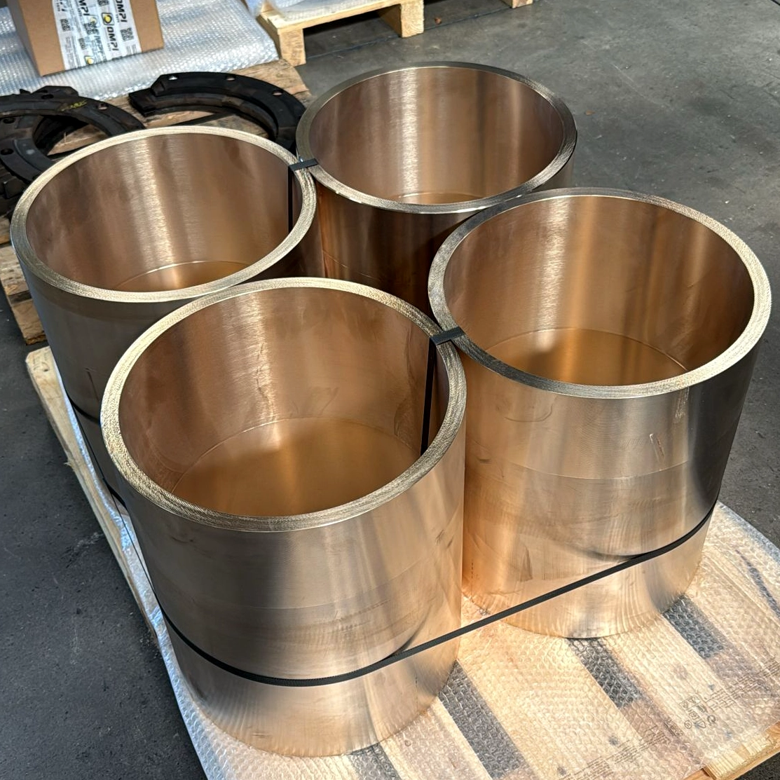 Set of four large bronze bushings on pallet, just shipped in.